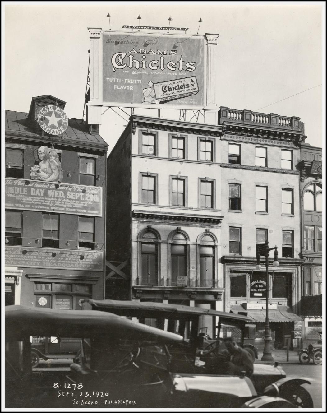 A black and white photo of a building with a sign on it

Description automatically generated with low confidence